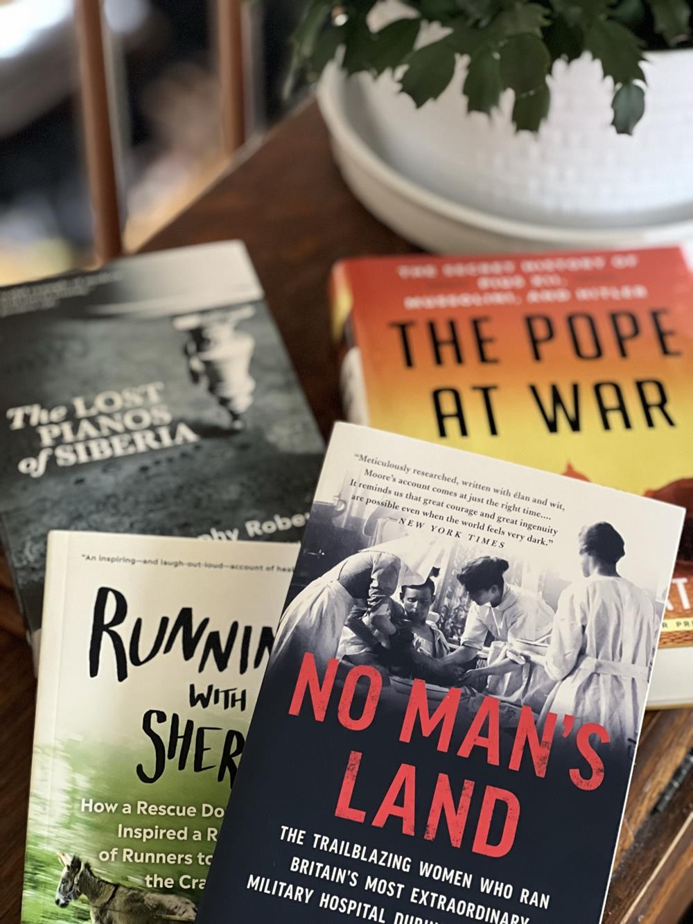four nonfiction books on a table